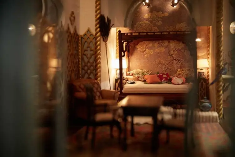 Dimly lit four-poster bedroom with carved wooden panelling