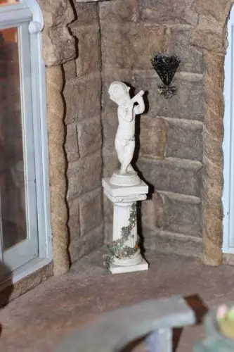 Cherub statue on a pedestal in a stone corner of the castle