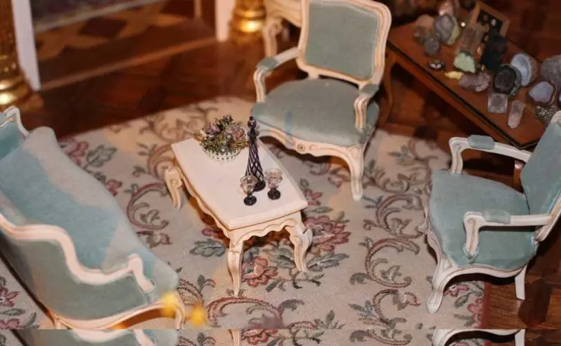 Sitting room with pale blue armchairs, a white coffee table and a plate collection on the wall